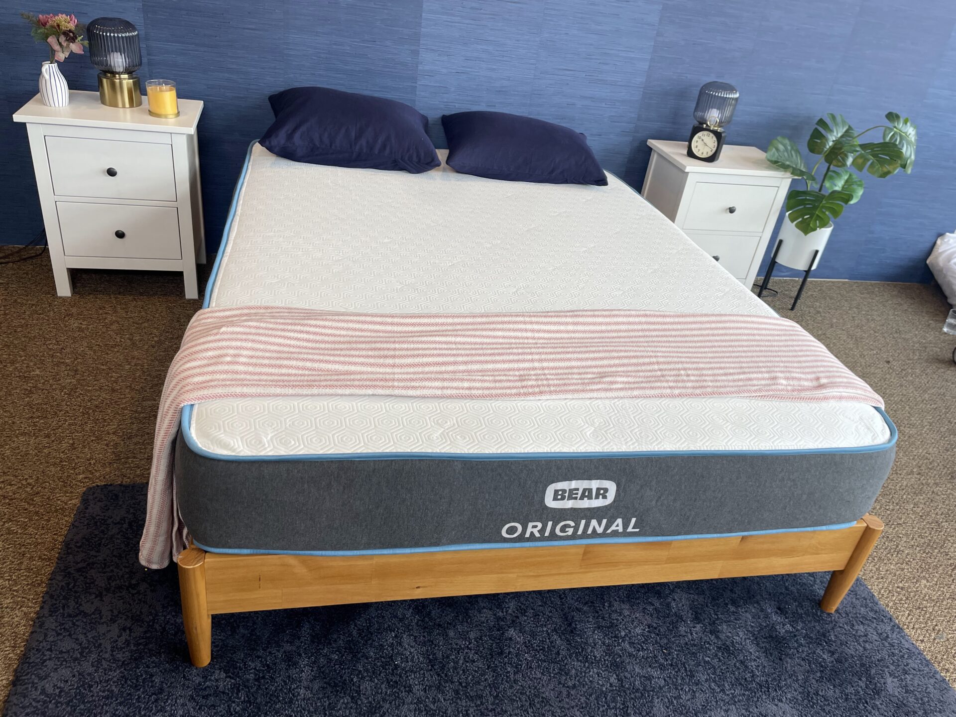 Bear Original mattress with navy pillows and a striped blanket