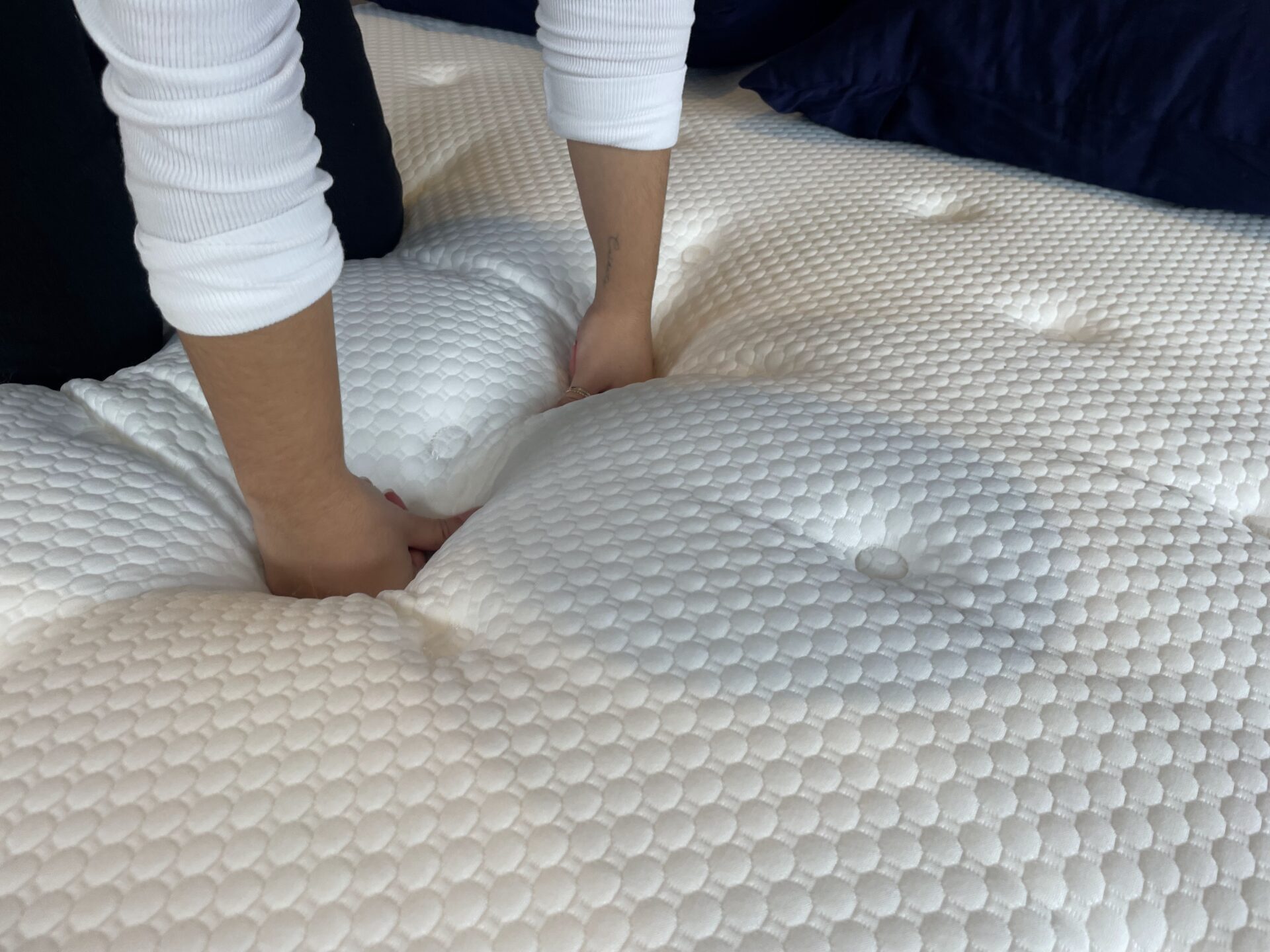 Person pressing down on Nolah Original Hybrid mattress surface